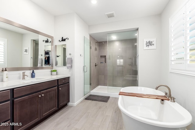 17311 W Seldon Ln, Waddell, AZ 85355 - full bath featuring a stall shower, a freestanding bath, vanity, and wood finished floors