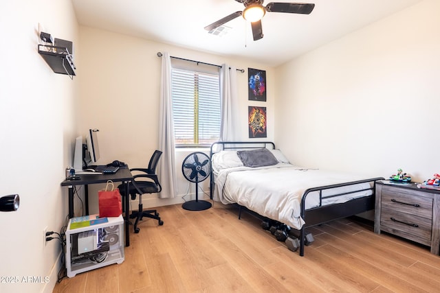 bedroom featuring light wood-type flooring, ceiling fan, visible vents, and baseboards