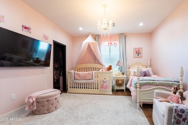 bedroom featuring baseboards, visible vents, wood finished floors, a notable chandelier, and recessed lighting