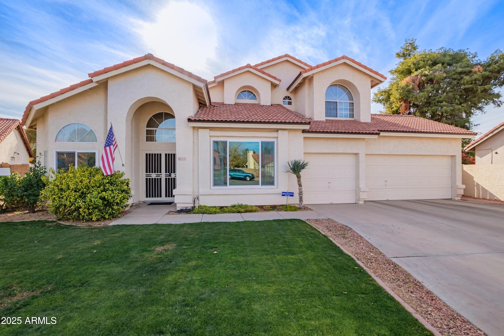 mediterranean / spanish-style house featuring a garage and a front yard