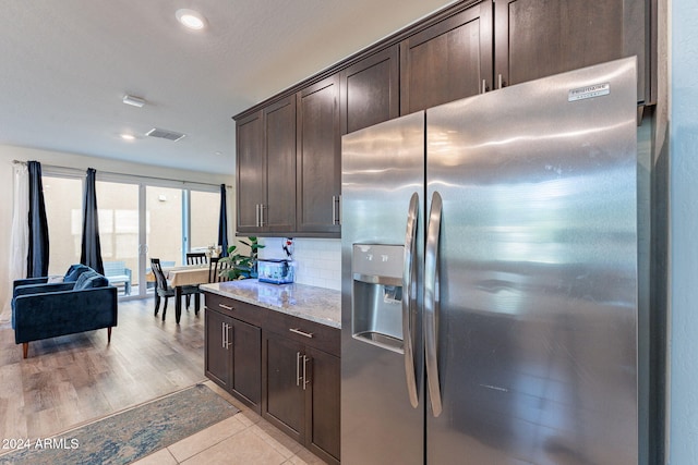 kitchen with decorative backsplash, stainless steel fridge with ice dispenser, dark brown cabinetry, and light hardwood / wood-style flooring