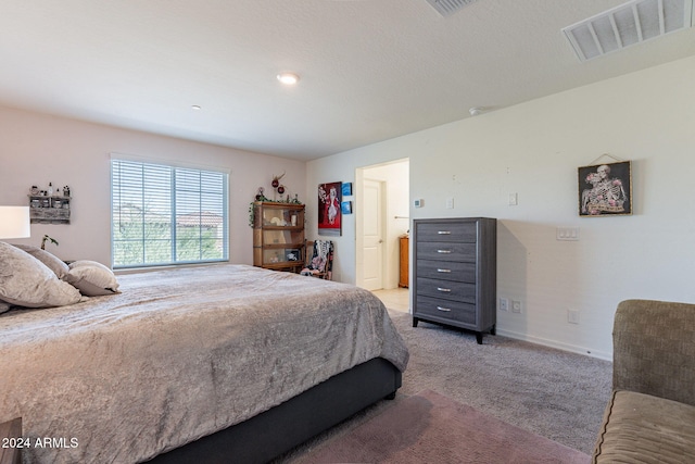 bedroom with visible vents, baseboards, and light colored carpet
