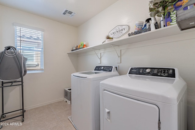 laundry room featuring laundry area, visible vents, light tile patterned floors, baseboards, and washer and clothes dryer