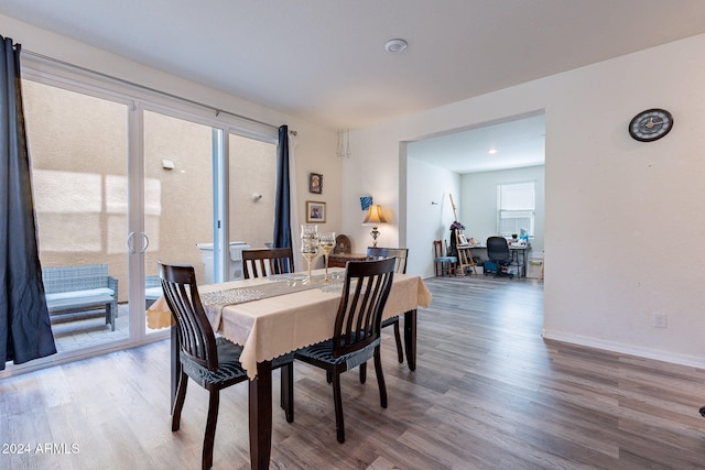 dining space with french doors, baseboards, and wood finished floors