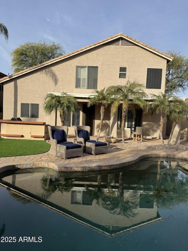 back of property with a pool with hot tub, outdoor lounge area, and a patio