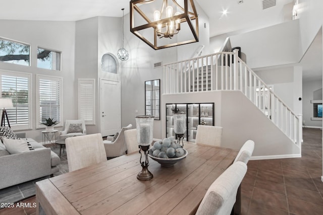 dining room featuring tile patterned floors, a fireplace, high vaulted ceiling, and a notable chandelier