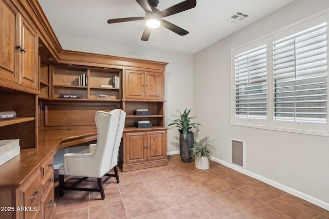 tiled home office with ceiling fan and built in desk