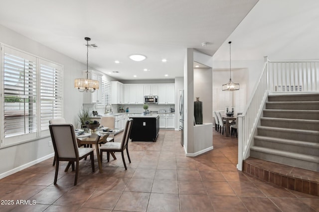 dining room featuring light tile patterned flooring, sink, and a notable chandelier