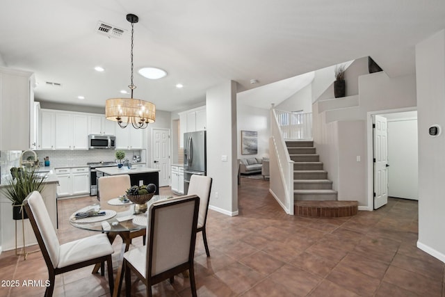 dining space featuring dark tile patterned flooring and an inviting chandelier