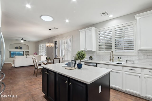 kitchen featuring white cabinetry, a center island, sink, and hanging light fixtures