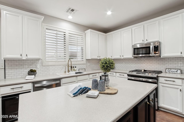 kitchen with white cabinetry, sink, decorative backsplash, and appliances with stainless steel finishes