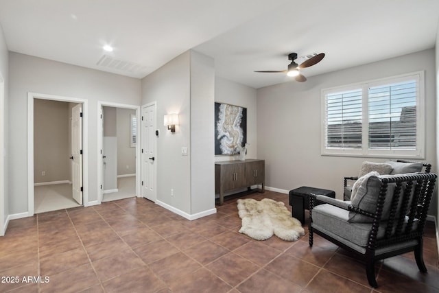 living area with tile patterned floors and ceiling fan