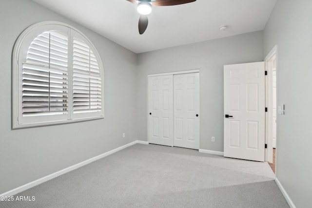 unfurnished bedroom featuring light carpet, ceiling fan, and a closet