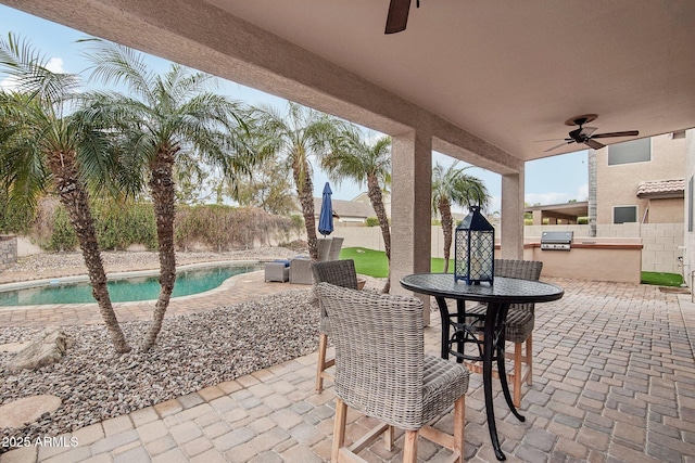 view of patio featuring ceiling fan, an outdoor kitchen, grilling area, and a fenced in pool