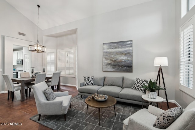 living room with high vaulted ceiling and a chandelier