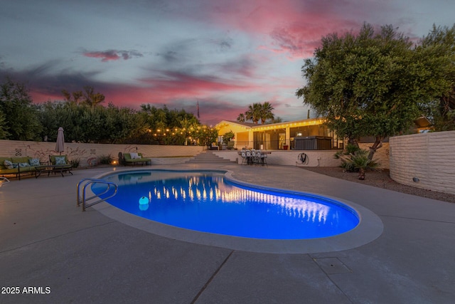 pool at dusk with a patio area