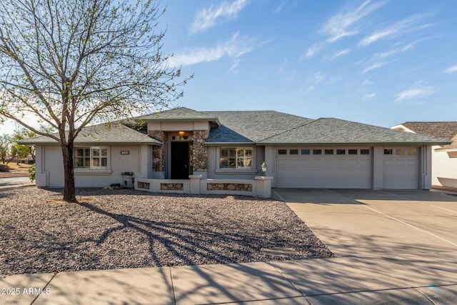 view of front facade featuring concrete driveway, a shingled roof, an attached garage, and stucco siding