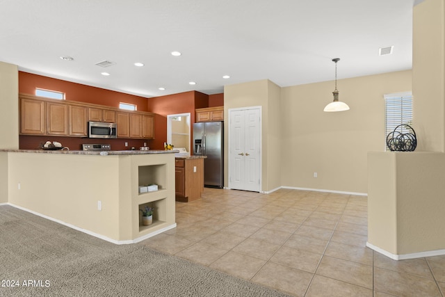 kitchen with decorative light fixtures, appliances with stainless steel finishes, light stone counters, a kitchen island, and light tile patterned floors