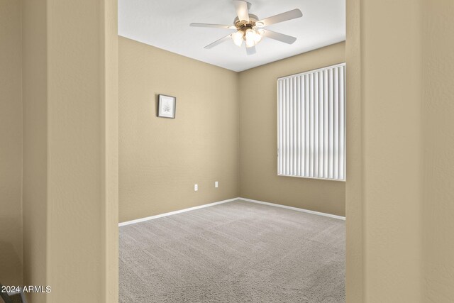 unfurnished room with ceiling fan and carpet