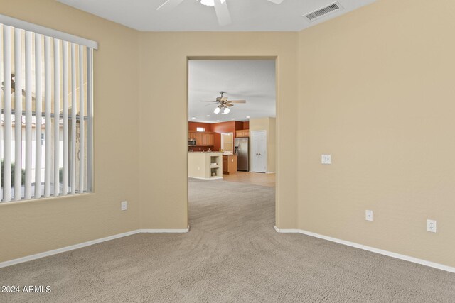 unfurnished room with ceiling fan and light carpet