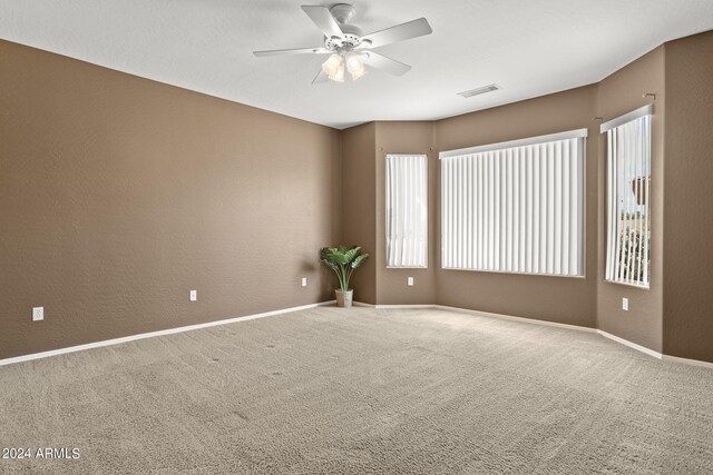 unfurnished room with ceiling fan and carpet