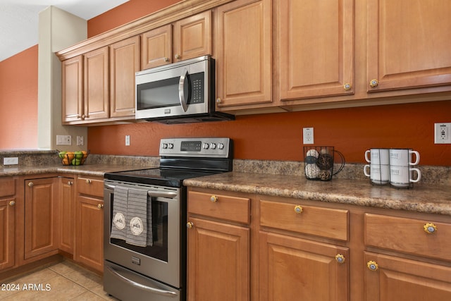 kitchen with light tile patterned floors and stainless steel appliances