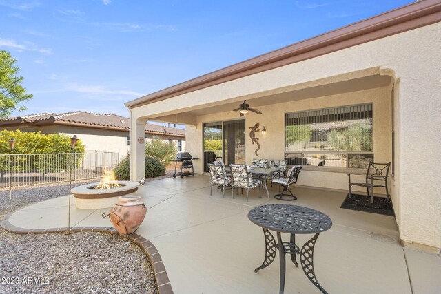 view of patio with ceiling fan, an outdoor fire pit, and a grill