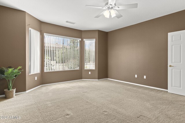 carpeted spare room featuring ceiling fan