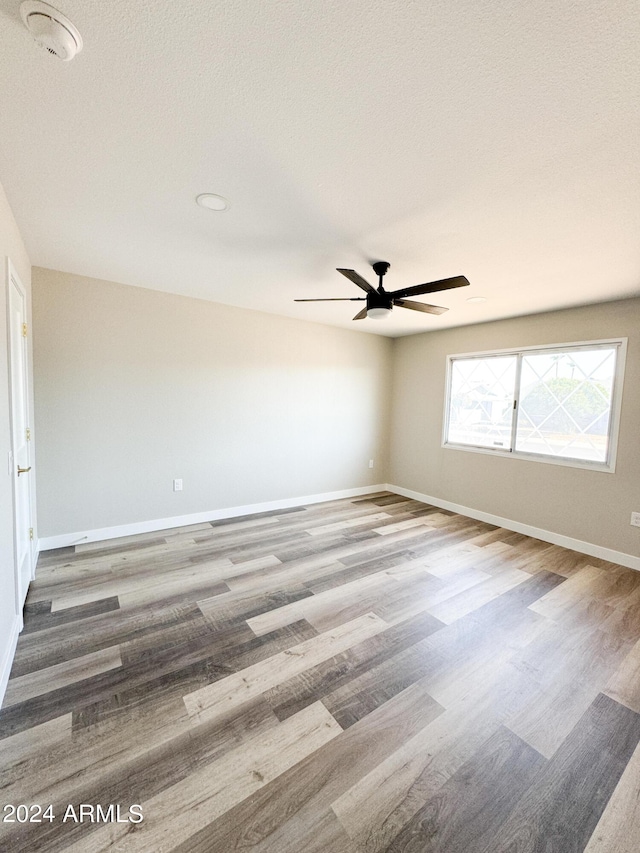 empty room with wood-type flooring and ceiling fan