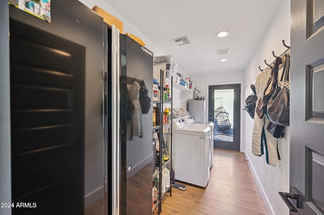washroom featuring water heater, separate washer and dryer, light wood finished floors, recessed lighting, and baseboards