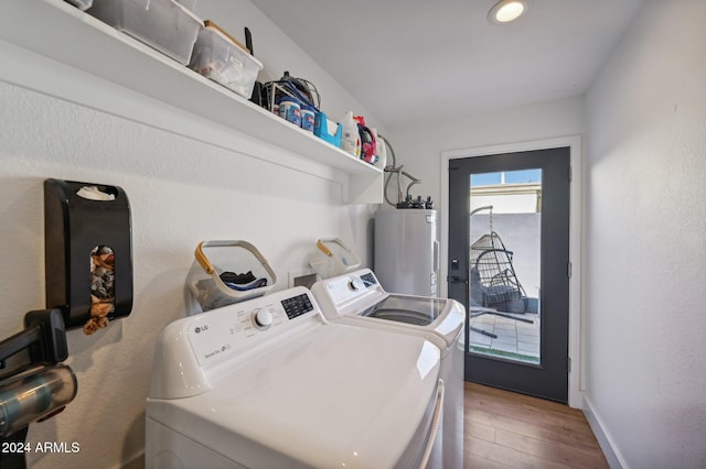 laundry room featuring separate washer and dryer, electric water heater, wood finished floors, and baseboards