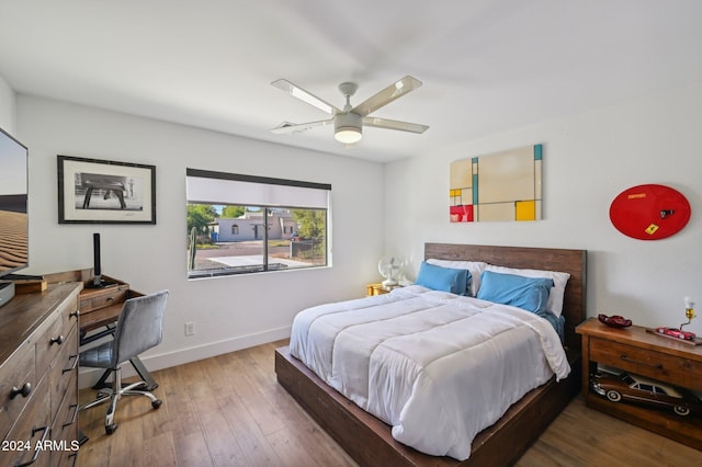 bedroom with baseboards, wood finished floors, and ceiling fan