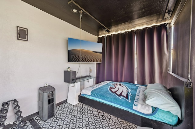 bedroom with tile patterned floors and baseboards