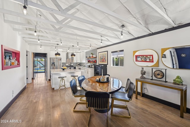 dining room with healthy amount of natural light, baseboards, and light wood-style flooring