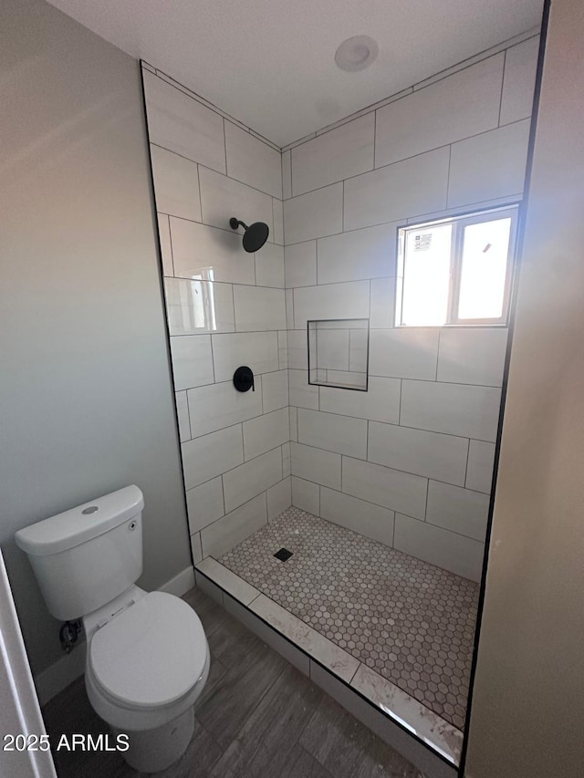 36269 W Highland Ave, Phoenix, AZ 85033 - bathroom with a tile shower, toilet, and wood finished floors