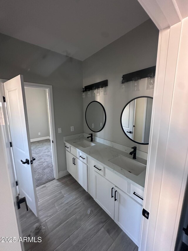 36269 W Highland Ave, Phoenix, AZ 85033 - bathroom with double vanity, wood finished floors, and baseboards