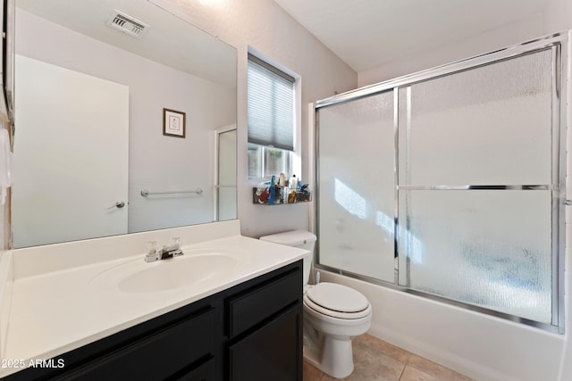 full bathroom featuring vanity, tile patterned floors, shower / bath combination with glass door, and toilet