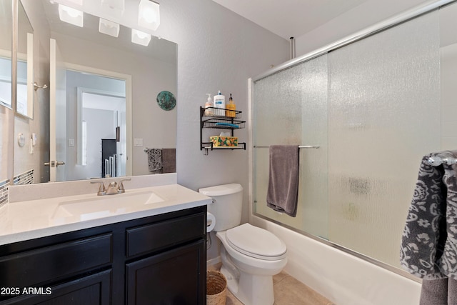 full bathroom with vanity, tile patterned floors, shower / bath combination with glass door, and toilet