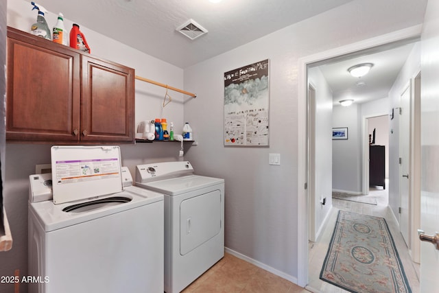 washroom featuring cabinets, separate washer and dryer, and light tile patterned floors