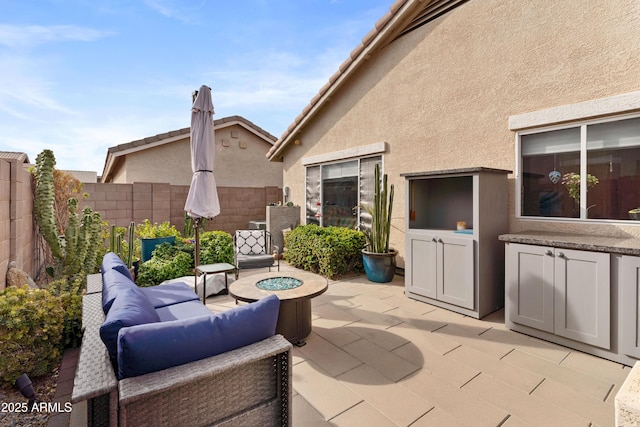 view of patio with an outdoor living space with a fire pit