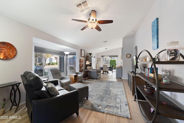 living room featuring wood-type flooring, lofted ceiling, a healthy amount of sunlight, and ceiling fan