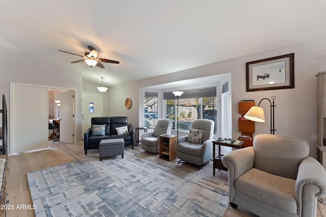 living room featuring vaulted ceiling, ceiling fan, and light hardwood / wood-style flooring