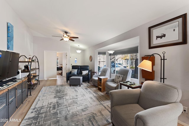 living room featuring wood-type flooring, lofted ceiling, and ceiling fan