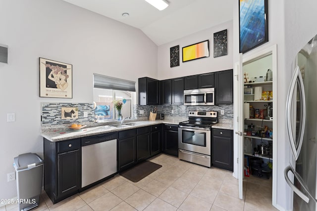 kitchen with sink, light tile patterned floors, stainless steel appliances, tasteful backsplash, and light stone counters