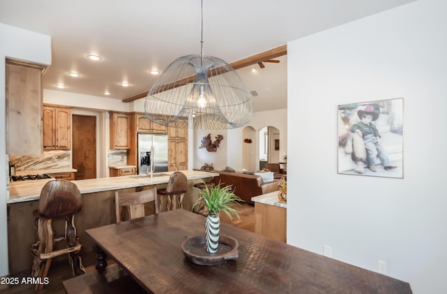 dining space featuring arched walkways and recessed lighting