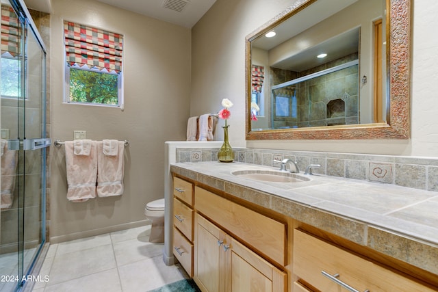 bathroom with vanity, tile patterned flooring, toilet, and a shower with shower door