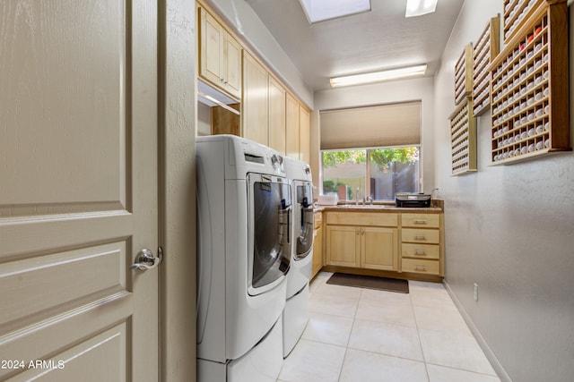 washroom with cabinets, separate washer and dryer, light tile patterned flooring, and sink