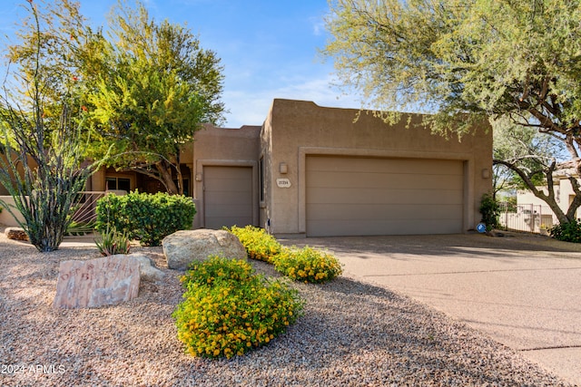 pueblo revival-style home featuring a garage