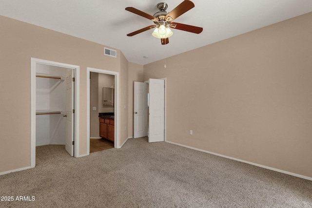 7101 W Beardsley Rd Unit 1502, Glendale, AZ 85308 - unfurnished bedroom featuring light carpet, a walk in closet, baseboards, lofted ceiling, and a closet