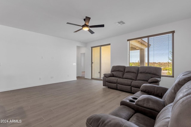 living room featuring light hardwood / wood-style flooring and ceiling fan